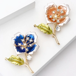 Elegant flower brooches in blue and orange enamel with crystal accents and gold plating