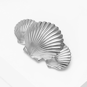 Detailed close-up of light luxury stainless steel brooch with three overlapping shells