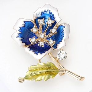 Macro view of blue and white enamel flower brooch with sparkling rhinestone accents