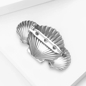 Detailed back view of silver seashell brooch showing secure metal pin clasp and welding