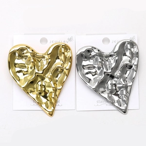 Macro view of gold and silver hammered stainless steel heart-shaped brooches