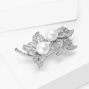 Détail de la broche feuille argentée avec cristaux brillants et deux perles blanches