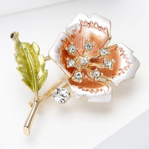 Close-up of elegant flower brooch with orange-pink enamel petals and crystal center