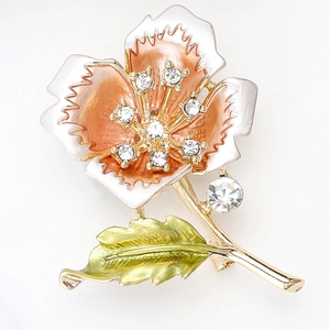Detail of flower brooch with orange enamel petals and sparkling rhinestone core