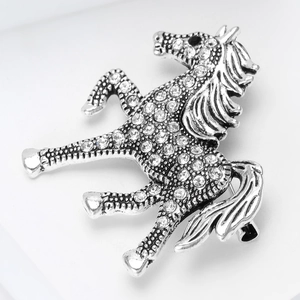 Macro shot of silver horse brooch with sparkling rhinestones and detailed textures