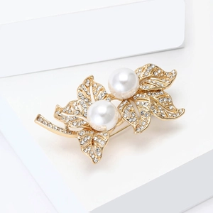 Détail de l'élégante broche feuille de perles avec cristaux brillants sur base dorée