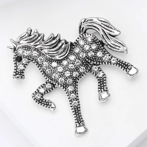 Macro view of silver galloping horse brooch with sparkling micro-paved rhinestones