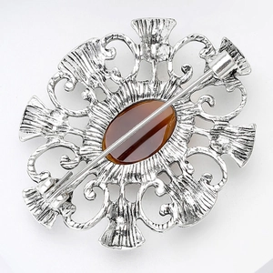 Vue détaillée du dos d'une broche chardon vintage avec pierre d'ambre et épingle