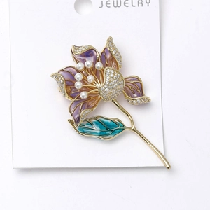 Détail de la broche lotus de luxe avec pétales violets, strass et perles blanches