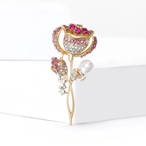 Détail d'une broche rose avec des strass roses et un accent de perle blanche élégante