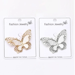 Detailed close-up of double-layer shell butterfly brooches in gold and silver finishes