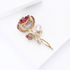 Détail de la broche rose en cristal rose avec une perle blanche sur métal doré