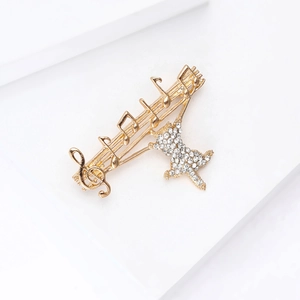 Detail of a gold-plated musical cat brooch with sparkling white rhinestones and music notes
