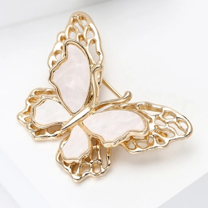 Detailed close-up of double-layer butterfly brooch with shell inlay and golden frame