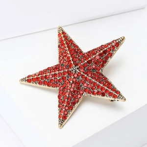 Detailed macro view of vintage star brooch with red rhinestones and textured gold plating