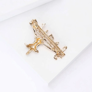 Detailed back view of golden alloy cat and musical note brooch with safety pin fastener