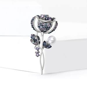 Détail d'une broche fleur de luxe avec strass bleus et perle blanche ronde