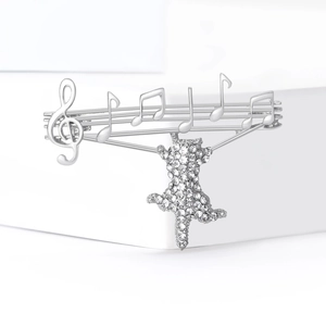 Silver musical note cat brooch with sparkling crystals on a minimalist white background