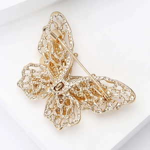 Macro detail of golden butterfly brooch back showing secure metal pin clasp mechanism