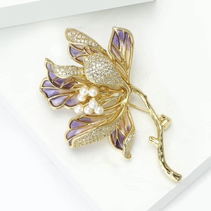Macro detail of purple gradient lotus brooch with sparkling rhinestones and white pearls