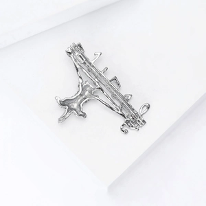 Detailed view of silver cat brooch with musical notes on a white geometric background