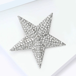 Detail of a vintage star brooch featuring sparkling rhinestones on a silver base