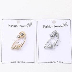 Vue détaillée de broches hibou évidées en or et argent avec yeux en perles grises