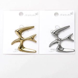 Detailed view of bird-shaped stainless steel brooches in gold and silver finishes