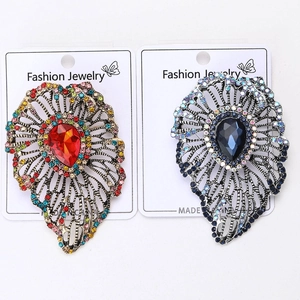 Detailed macro view of vintage hollow leaf brooches with colorful crystal teardrops