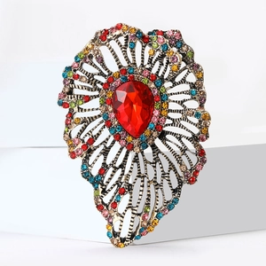 Vintage hollowed-out brooch with a large red teardrop gem and colorful crystal accents