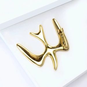 Detailed view of polished gold swallow bird brooch with secure pin back fastener