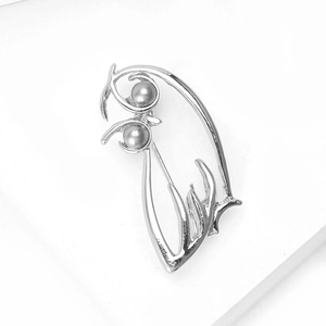 Détail macro de la broche fleur argentée minimaliste avec perles grises élégantes