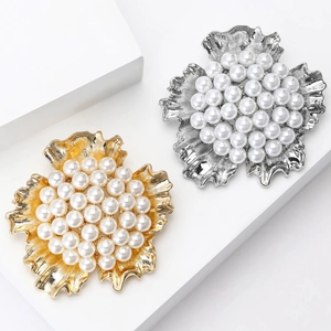 Elegant floral pearl brooches in gold and silver finish on minimalist white steps