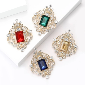 Elegant Baroque brooch set with colorful crystals and gold filigree on white background