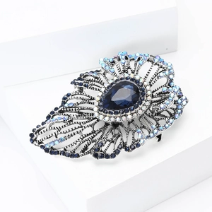 Macro shot of vintage silver brooch with teardrop blue stone and crystal details