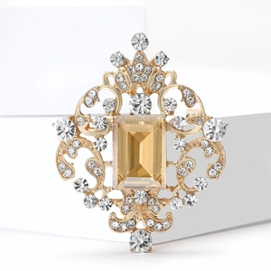 Detail of vintage palace style brooch with amber glass and golden filigree texture