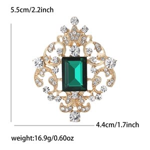 Macro detail of vintage brooch showing dimensions 5.5cm by 4.4cm with emerald green stone