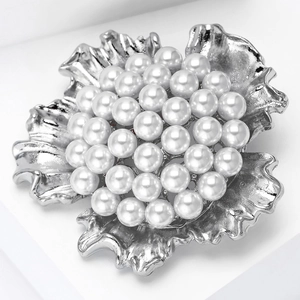 Macro shot of elegant heavy duty flower brooch with white pearls and silver petals
