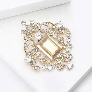 Detailed close-up of Baroque style golden brooch with champagne glass gemstone and rhinestones