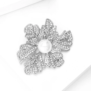 Détail d'une broche feuille argentée avec strass pavés et une perle blanche centrale