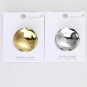 Close-up of gold and silver stainless steel round brooches with irregular metal textures