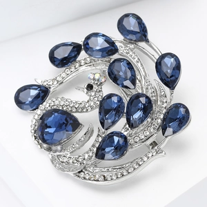 Macro shot of silver peacock brooch with navy blue crystals and white zircons