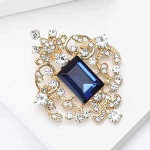 Macro detail of vintage rectangle sapphire brooch with gold filigree and crystals