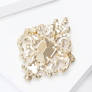 Macro view of the gold-plated baroque filigree back and pin fastener of the brooch
