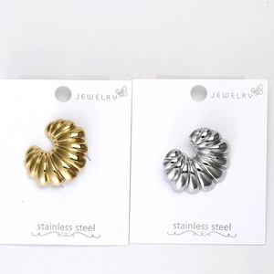 Macro detail of ribbed C-shaped earrings in gold and silver stainless steel finishes