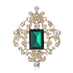 Vintage Baroque brooch with a large emerald green stone and sparkling crystals on gold metal