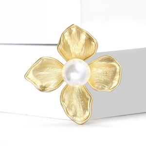 Elegant gold flower brooch with brushed metal petals and a central white pearl detail