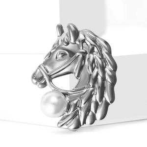 Broche tête de cheval argentée élégante avec grande perle blanche sur un socle moderne