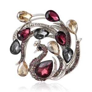 Elegant peacock brooch featuring colorful crystals and pink rhinestones on a silver frame
