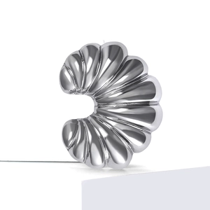 Macro shot of silver croissant brooch with detailed radial folds and polished finish